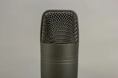 Un micro de studio gris vu de près, sur un fond gris clair